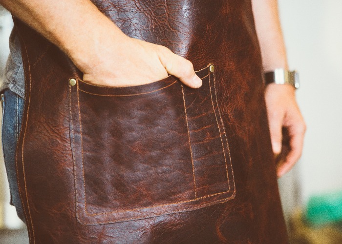 Male hand in pocket of leather apron